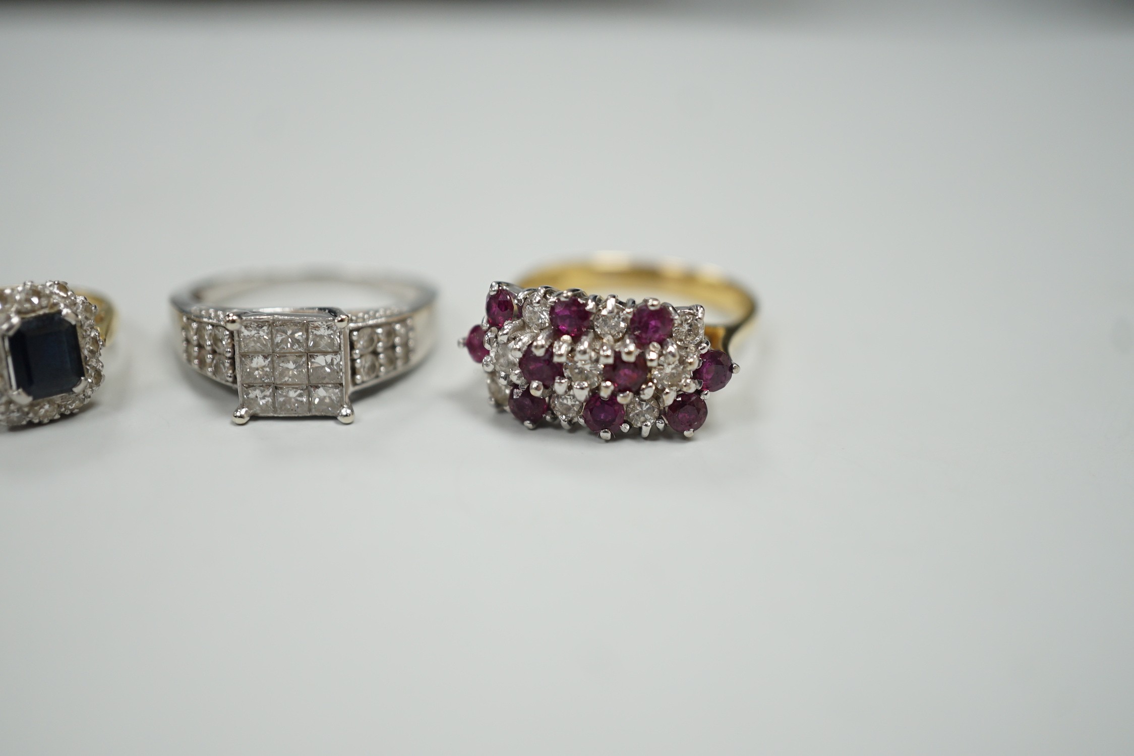 Three assorted modern gem set rings, including white metal and diamond cluster tablet ring with diamond set shoulders, an 18ct gold, sapphire and diamond cluster set ring and an 18ct gold ruby and diamond set cluster rin